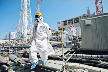  ?? ?? Indelible image: visitors survey the damage at the Fukushima nuclear plant in Japan two years after it was crippled by a tsunami in 2011