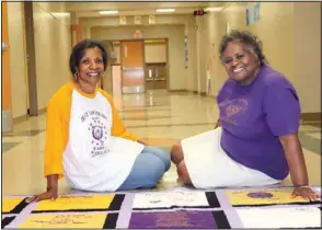  ?? (Arkansas Democrat-Gazette/Helaine R. Williams) ?? Dr. Frances Harris and Brenda Gilbert perch in front of a quilt that will be among the silent auction items at the Horace Mann Transition­al Class of 1972’s Solid Gold Class Reunion. The quilt features nods to the former, all-Black Horace Mann and Dunbar high schools; graduates of the two schools combined to form the Dunbar Horace Mann Alumni Associatio­n.