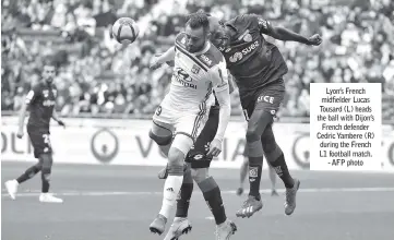  ??  ?? Lyon’s French midfielder Lucas Tousard (L) heads the ball with Dijon’s French defender Cedric Yambere (R) during the French L1 football match. - AFP photo