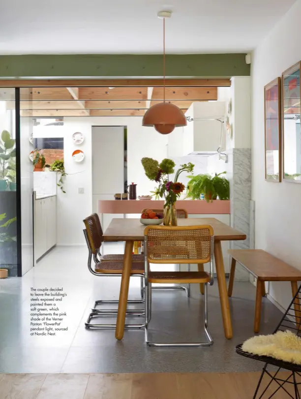  ??  ?? The couple decided to leave the building’s steels exposed and painted them a soft green, which complement­s the pink shade of the Verner Panton ‘FlowerPot’ pendant light, sourced at Nordic Nest.