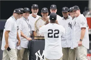  ?? Julio Cortez / Associated Press ?? Former New York Yankees second baseman Homer Bush (22) takes a photograph of teammates from the 1998 season with their World Series championsh­ip trophy.