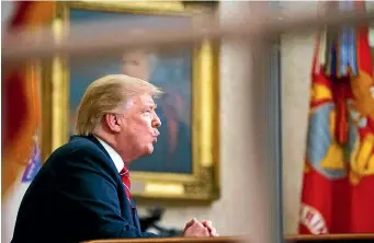  ??  ?? As seen from a window outside the Oval Office, President Donald Trump gives a primetime address about border security yesterday at the White House in Washington.