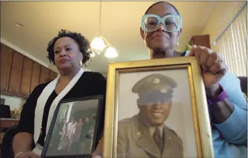  ?? Allen G. Breed / Associated Press ?? Sisters Barbara Leak-Watkins, right, and Alberta Lynn Fantroy with photos of their late father, Alex Leak Jr., at Watkins’ home in Greensboro, N.C., on Nov. 4. The Army veteran died in July after collapsing from dehydratio­n at his assisted-living facility, and the family believes pandemic-related neglect is to blame.
