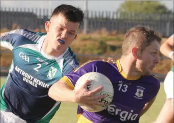  ??  ?? Tommy Morris of St. Patrick’s tries to steal a march on Volunteers defender Brian Delaney.