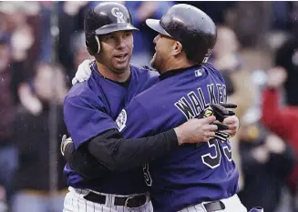  ?? Brian Bahr, Getty Images ?? Rockies right fielder Larry Walker, right, celebrates with first baseman Todd Helton in 2003. “When I talk about Larry, I say he is the best athlete I ever played with,” Helton says.