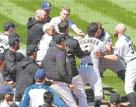  ?? Matthew Stockman, Getty Images ?? Both benches clear as a brawl breaks out between the Rockies and Padres in the third inning at Coors Field on Wednesday.