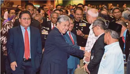  ?? BERNAMA PIC ?? Deputy Prime Minister and Home Minister Datuk Seri Dr Ahmad Zahid Hamidi greeting people at the ministry’s monthly assembly in Putrajaya yesterday. With him is Deputy Home Minister Datuk Nur Jazlan Mohamed (left).