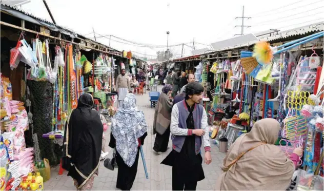  ?? Ag r ?? ↑
Residents walk through a weekly market in Islamabad on Friday.