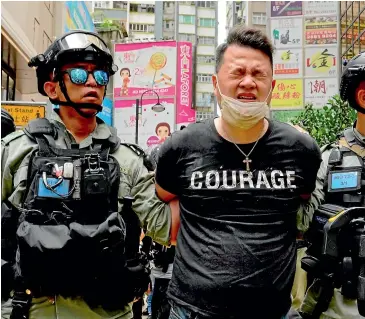  ?? AP ?? Police detain a protester after he was pepper-sprayed during a protest in Causeway Bay before the annual handover march in Hong Kong this week.
