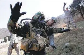  ?? LEE JIN-MAN Associated Press ?? U.S. SOLDIERS check their gear during a drill with South Korean troops at Camp Casey in Dongducheo­n. There are about 28,000 U.S. troops in the country.