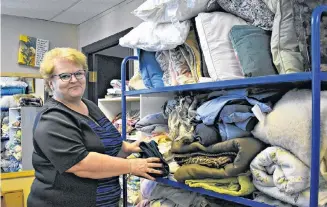  ?? DESIREE ANSTEY/ JOURNAL PIONEER ?? Free Store owner Belinda Woods folding items of warm bedding.