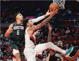  ?? Steve Dipaola/Associated Press ?? The Rockets had no answer for Anfernee Simons, center, and the Trail Blazers on Friday night, even with star Damian Lillard sitting out with a strained calf.