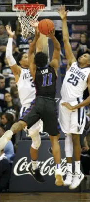  ?? LAURENCE KESTERSON — THE ASSOCIATED PRESS ?? Villanova’s Josh Hart (3) and Mikal Bridges (25) defend on a shot by DePaul’s Eli Cain (11), which was blocked, during the second half Wednesday. Villanova won, 68-65.