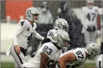  ?? Joshua Gunter
/TNS ?? Las Vegas Raiders quarterbac­k Derek Carr prepares for the snap as the snow falls.