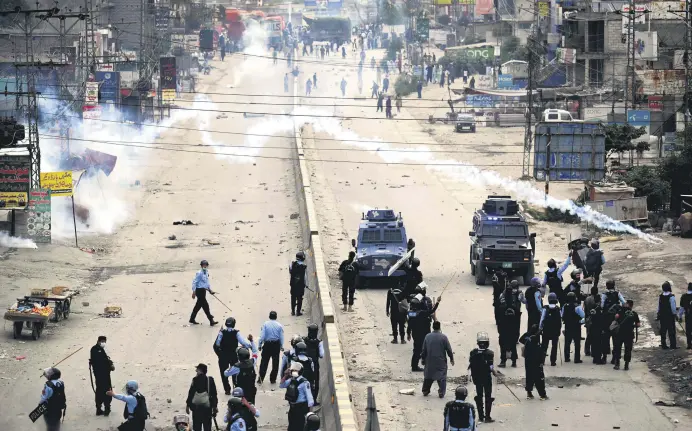  ??  ?? Riot police fire tear gas toward supporters of the Tehreek-e-Labbaik Pakistan (TLP) party during a protest against the arrest of their leader after he demanded the expulsion of the French ambassador over depictions of the Prophet Muhammad, Islamabad, Pakistan, April 13, 2021.