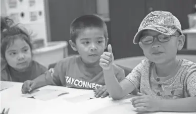  ??  ?? Aiden Gonzalez, left, Zyvier French and Colten Huma sample pumpkin seeds during a pre-kindergart­en program at Salt River Elementary School.