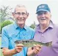  ??  ?? Golfers Paul Friend and Tony Wright with the trout left behind by a bird of prey