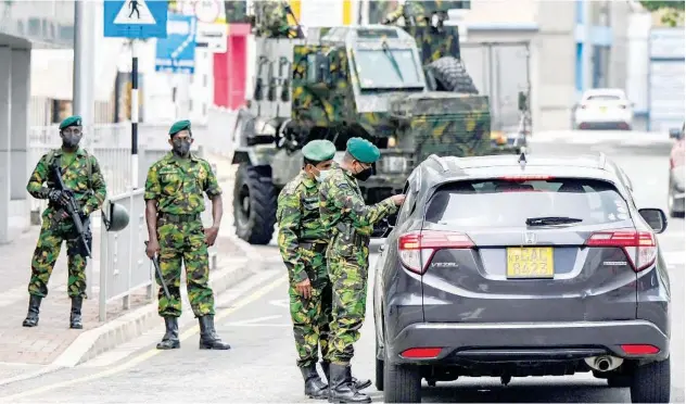  ?? Agence France-presse ?? ↑
Soldiers check documents of a driver at a road checkpoint in Colombo on Wednesday.