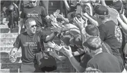  ??  ?? Louisville football coach Scott Satterfiel­d greets fans before a game against Notre Dame last season.