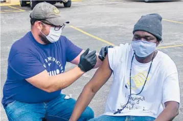  ?? JEREMY MCCRAW/NEIGHBORHO­OD HEALTH ?? Dr. Pete Cathcart vaccinates Deng Autiak this month in Nashville, Tennessee. Many organizati­ons have set a goal of bringing vaccine to everyone experienci­ng homelessne­ss in Nashville by Memorial Day.