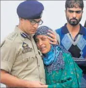  ?? WASEEM ANDRABI/ HT ?? A police officer in Srinagar comforts the wife of slain policeman Habibullah who died on Friday. He was critically injured in a militant attack in the J&K capital last week.