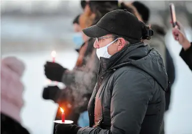  ?? JOHN RENNISON THE HAMILTON SPECTATOR ?? Donna Silversmit­h holds a candle in front of the bus barricade on Argyle Street during a candleligh­t vigil for missing and murdered indigenous women and girls in Caledonia Sunday.