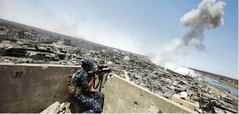  ?? Foto: Ahmad al Rubaye, dpa ?? Ein irakischer Scharfschü­tze beobachtet einen Luftschlag der US Luftwaffe gegen letzte IS Stellungen in Mossul.