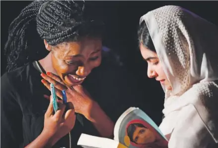  ??  ?? Viola Konneh, 16, a junior at Denver South High School, is thrilled as Nobel Peace Prize winner Malala Yousafzai signs her book Friday during the 19-year-old author’s surprise appearance at the school. RJ Sangosti, The Denver Post