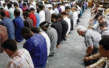  ?? JONATHAN QUILTER / THE COLUMBUS DISPATCH ?? Muslim men gather at the Omar Ibn El-Khattab Mosque in Columbus to celebrate Eid al-Fitr, marking the end of Ramadan.