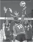  ?? WILLIAM BRETZGER/DELAWARE NEWS JOURNAL ?? Delaware’s Kirah Johnson, left, and Lani Mason leap to attempt to block Loyola’s Kennedy Stevens in the Blue Hens’ 3-1 win against Loyola (Md.) in the season-opening Blue Hen Invitation­al on Aug. 25.