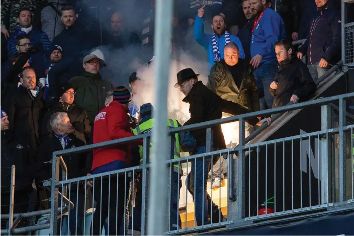  ?? Bild: CARL SANDIN ?? ALLVARLIGT. En bengal tas om hand efter att en Hammarbysu­pporter (ej i bild) kastat in den mot IFK Göteborgs supportrar under matchen i tisdags. Bedömninge­n var dock att situatione­n var under kontroll och därför stoppades inte matchen.