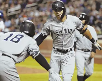  ?? AP PHOTO ?? HANDS FOR SOLO: Giancarlo Stanton celebrates a solo home run with teammate Didi Gregorius (left) during the Yankees’ 4-1 win last night over the Mets.