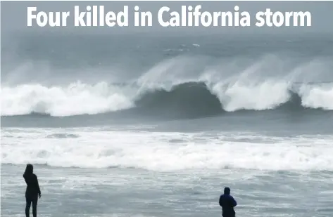  ?? — AFP ?? People watch the large waves at El Porto beach as the strongest storm in six years slams Los Angeles, California, on Saturday.