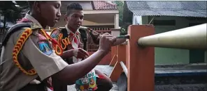  ??  ?? GOTONG ROYONG: Dari kiri, Sodiq Sholahudin dan Bagus Darmansyah dari SMKN 1 Geger Madiun mengecat jembatan.