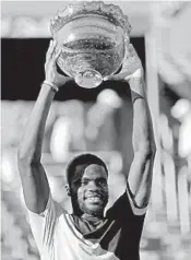  ?? JOHN MCCALL/AP ?? Frances Tiafoe, who almost missed entering the tournament, hoists the Delray Beach Open trophy after Sunday’s victory against Peter Gojowczyk.