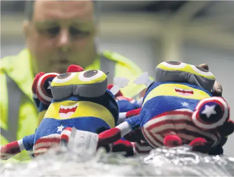  ??  ?? Border Force officer Robert Martin with children’s toys which were among the goods seized at a UK port.