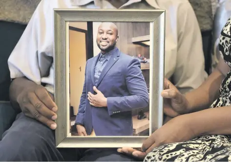 ?? Pictures: Tracy Lee Stark ?? HAPPY TIMES. Joseph and Angela Mhere, the parents of Simba Mhere, hold up a photograph of their son, who was killed in a car accident. His mother and father spoke to The Citizen at their home in Honeydew.