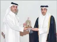  ?? ?? Minister of Labour HE Dr. Ali bin Smaikh Al Marri hands over the award to GWC Executive Director Nawaf Al Emadi.