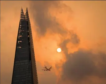  ??  ?? Into the clouds: A plane passes the Shard skyscraper in central London