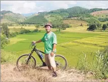  ?? Arnie Cooper ?? PHUBORDIN THITIPONGK­UL, known as Mr. Bee, of Chiang Rai Bicycle Tour, above a rice paddy on the Thai city’s outskirts.