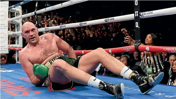  ?? AP ?? Tyson Fury is knocked down during the ninth round of his heavyweigh­t fight against Deontay Wilder, which ended in a draw.