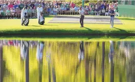  ?? ASSOCIATED PRESS ?? Tiger Woods and Will Zalatoris skip golf balls across the water on the 16th hole during a practice round in preparatio­n for the Masters golf tournament at Augusta National Golf Club on Monday in Augusta, Ga.