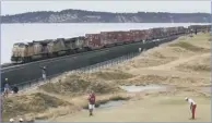  ?? Picture: AP ?? Rickie Fowler lines up a putt on the 17th green as a freight train passes by