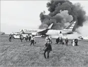  ?? COURTESY OF ALAN LEMERY 2016 ?? Passengers flee an American Airlines plane at O’Hare Airport after the right-hand engine exploded and caught fire.