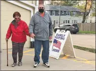  ?? (AP/Geoff Mulvihill) ?? Tim and Pat Tompkins arrive to vote early Friday in Bettendorf, Iowa. The couple said they were concerned about coronaviru­s exposure in bigger crowds but were determined to vote, and carried their own hand sanitizer.