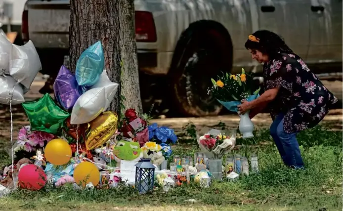  ?? DAVID J. PHILLIP/ASSOCIATED PRESS ?? Maria Rodriguez placed flowers Tuesday outside the home where a mass shooting occurred Friday, in Cleveland, Texas.