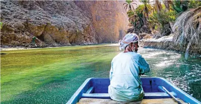  ??  ?? COOL TRIP:An Omani steers his boat down the river at the entrance to the dramatic Wadi Shab canyon