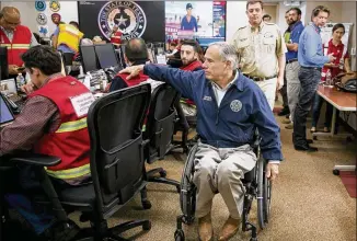  ?? JAY JANNER / AMERICANST­ATESMAN ?? Gov. Greg Abbott encourages emergency officials working at the State Operations Center on Friday in preparatio­n for Hurricane Harvey.