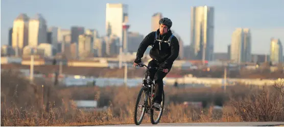  ?? TED RHODES ?? Luke Wall crests Lynnview Ridge above Beaverdam Flats on his 16-kilometre ride home from work at the Mustard Seed downtown to his Douglasdal­e home Monday.