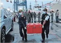  ?? DITA ALANGKARA THE ASSOCIATED PRESS ?? Members of the National Transporta­tion Safety Committee carry the flight data recorder of Sriwijaya Air flight SJ-182.